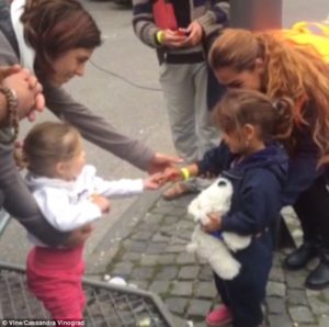 A German toddler shares her sweets with a Syrian refugee. Image from Cassandra Vinograd/Vine.