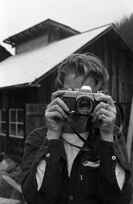 Woman looking at photographer holding a camera