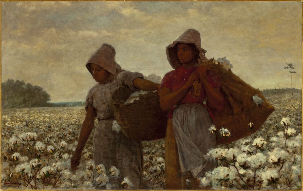 Two African American girls standing in a field of cotton, holding sacks and looking out across the landscape.