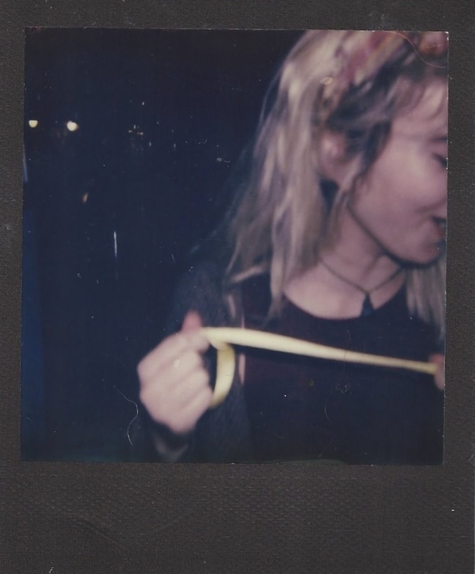 Girl holds string/ribbon with face slightly off camera.