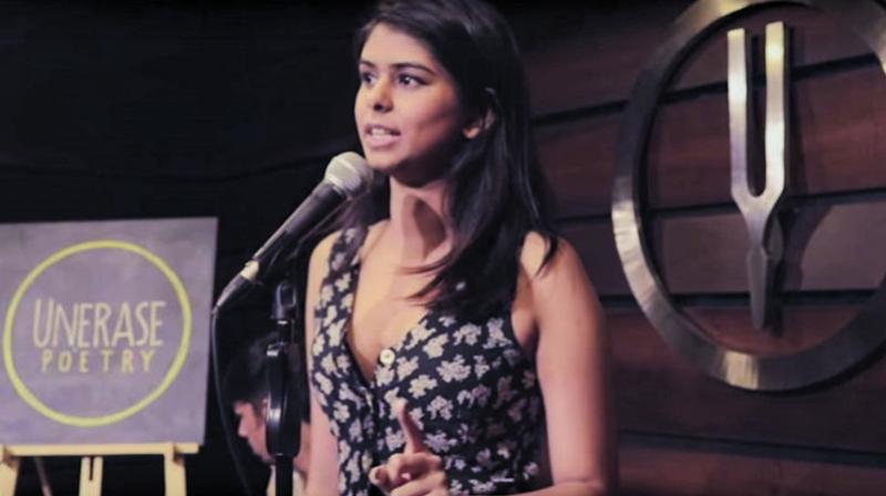 Aranya Johar in front of a mic at the Unerase Poetry event in 2017.