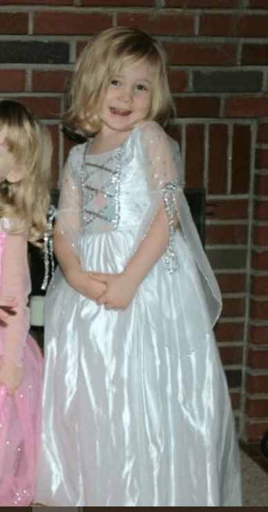 Blond haired girl dressed in white princess dress for Halloween.