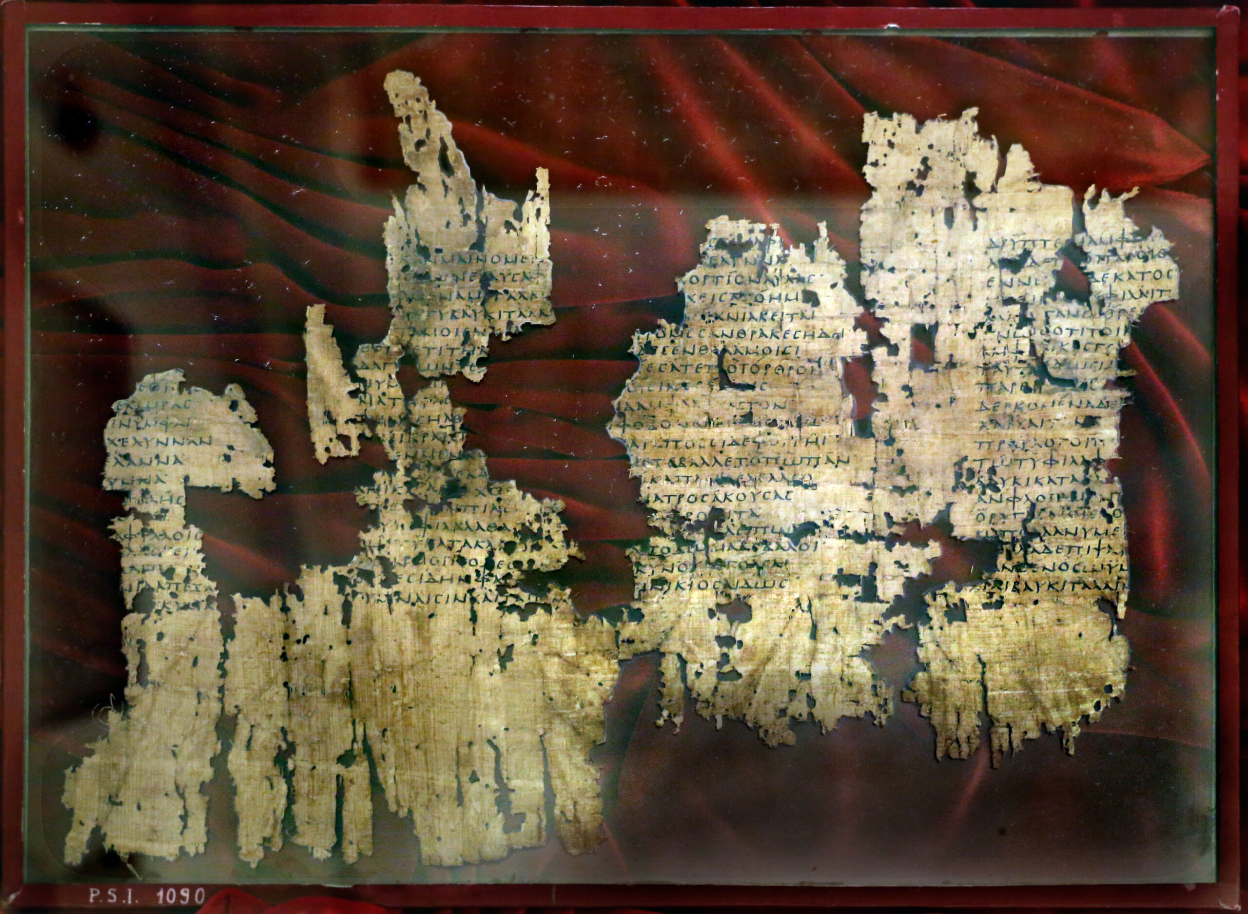 Fragments of Distaff by Erinna on a red fabric background.